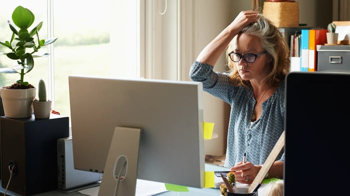 Persona trabajando frente a un ordenador en un entorno de oficina, relacionada con seguridad digital y posibles estafas online