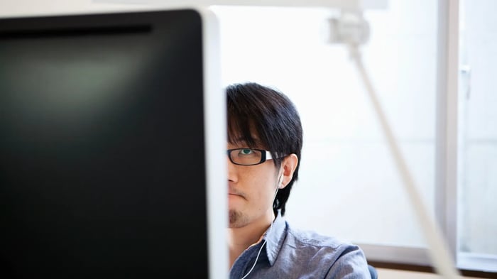 Persona trabajando frente a un monitor de ordenador en un entorno de oficina